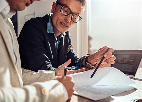 Empresário apontando o local do contrato onde o cliente deve assinar