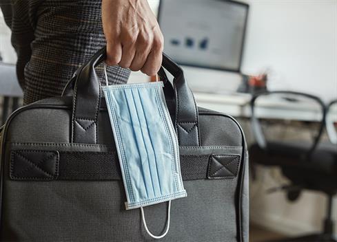 man holding mask and briefcase