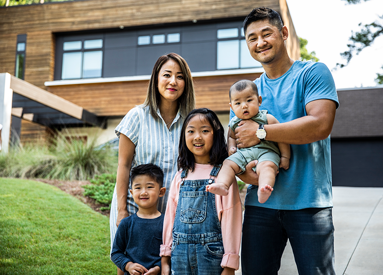 Asian-family-smiling-outside-home