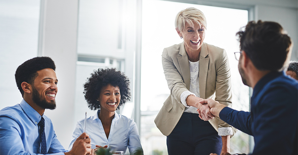 two businesspeople shaking hands in a meeting two businesspeople shaking hands in a meeting
