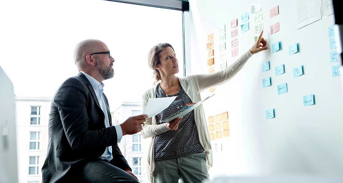 woman pointing at white board