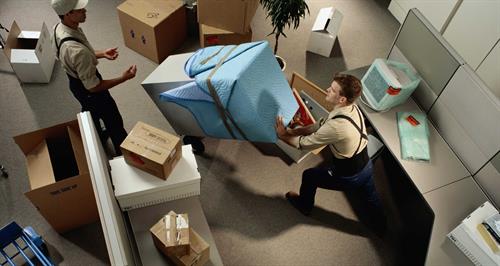 men move boxes in an office