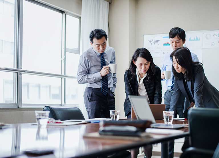 people in meeting looking at laptop