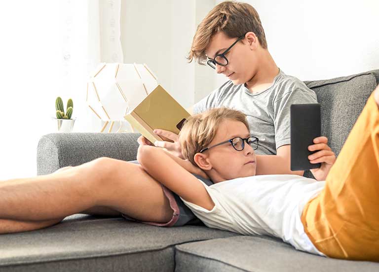 two-children-reading-on-a-couch