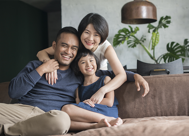 Young parents with child sitting on the sofa