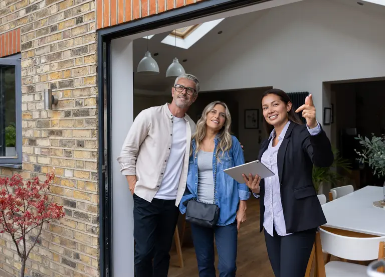 Real estate agent showing a house for sale to a couple
